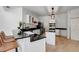Well-lit kitchen with white cabinets, black granite countertops, stainless steel appliances and wooden floors at 20003 Holly Lake Pl, Lutz, FL 33558