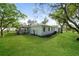 Spacious backyard featuring mature trees, green grass and a screened in porch at 10237 Bannock St, Spring Hill, FL 34608