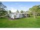 Exterior side view showcasing a lush green backyard at 10237 Bannock St, Spring Hill, FL 34608