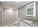 Bathroom featuring a walk-in shower, granite countertop vanity and stylish mirror at 10237 Bannock St, Spring Hill, FL 34608