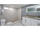 Bathroom featuring walk-in shower, granite countertop with double sinks, and a modern mirror at 10237 Bannock St, Spring Hill, FL 34608