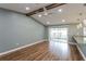 Living room featuring vaulted ceiling with beams, wood floors, and sliding glass doors to the outside at 10237 Bannock St, Spring Hill, FL 34608
