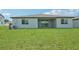 A sprawling green backyard with a covered patio and sliding glass doors at 13839 Richland Gulf Cir, Parrish, FL 34219