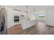 Modern kitchen with stainless steel appliances, white cabinets and hardwood style flooring at 13839 Richland Gulf Cir, Parrish, FL 34219
