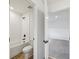 Bathroom with wood look tile, a white tiled shower and a view into a bedroom at 14035 Kelly Park Ct, Parrish, FL 34219