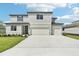 New construction two-story home featuring a three-car garage, modern design, and well-manicured front lawn at 14035 Kelly Park Ct, Parrish, FL 34219