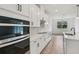 Modern kitchen with white cabinetry, stainless steel appliances, quartz countertops, and an island with bar seating at 14035 Kelly Park Ct, Parrish, FL 34219