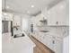 Bright, modern kitchen with white cabinets, stainless steel appliances, and tile backsplash at 14035 Kelly Park Ct, Parrish, FL 34219
