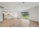 Open-concept living area with wood-look tile floors, flowing into the kitchen and overlooking a backyard at 14035 Kelly Park Ct, Parrish, FL 34219