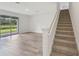 Bright, open living room with wood-look tile flooring, large glass sliding doors to the backyard and carpeted stairs at 14035 Kelly Park Ct, Parrish, FL 34219