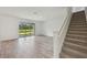 Bright, open living room with wood-look tile flooring, large glass sliding doors to the backyard and carpeted stairs at 14035 Kelly Park Ct, Parrish, FL 34219