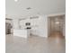Bright, open-concept kitchen with white cabinets, island, stainless appliances, and easy access to entry at 7736 Gilchrist Springs Dr, Parrish, FL 34219