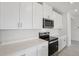 Modern kitchen with white cabinets, quartz countertops, stainless steel appliances, and a contemporary design at 7736 Gilchrist Springs Dr, Parrish, FL 34219