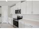 Modern kitchen with white cabinets, quartz countertops, stainless steel appliances, and a contemporary design at 7736 Gilchrist Springs Dr, Parrish, FL 34219