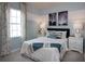 Comfortable bedroom with soft lighting, a large window, and stylish decor with a blue and white color scheme at 42854 Park View Dr Way, Punta Gorda, FL 33982