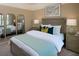 Serene bedroom featuring a neutral palette, ample pillows, and elegant mirrored accents at 42854 Park View Dr Way, Punta Gorda, FL 33982