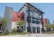 Modern building exterior with red and gray accents, mature landscaping, and covered entrance at 42854 Park View Dr Way, Punta Gorda, FL 33982