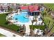 Aerial view of a resort-style pool with ample seating, lush landscaping, and vibrant umbrellas at 42854 Park View Dr Way, Punta Gorda, FL 33982