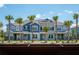 New townhomes boast vibrant exteriors and lush landscaping with palm trees and inviting entryways under a sunny, blue sky at 17378 Alderwood Ln, Punta Gorda, FL 33982