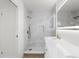 Elegant bathroom with a glass-enclosed shower, gold fixtures, and a lighted mirror above the vanity at 4284 Persian Ln, North Port, FL 34287