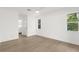 Bright bedroom with neutral wood-look flooring, white walls, and natural light from windows at 4284 Persian Ln, North Port, FL 34287