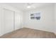 Simple bedroom with wood-look floors, closet and a window providing natural light at 4284 Persian Ln, North Port, FL 34287