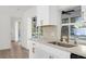 The modern kitchen features bright white cabinets, marble counters, and an updated faucet at 4284 Persian Ln, North Port, FL 34287