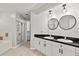 Bathroom with double vanity, black countertop, modern lighting and a standup shower at 6731 Northlake Dr, Zephyrhills, FL 33542