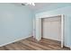 This bedroom has light blue walls, wood floors and standard closet with double doors at 6731 Northlake Dr, Zephyrhills, FL 33542