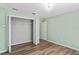 A minimalist bedroom with light green walls, wood floors and a standard closet at 6731 Northlake Dr, Zephyrhills, FL 33542