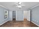 This bedroom has hard wood floors and large windows with natural light and a ceiling fan at 6731 Northlake Dr, Zephyrhills, FL 33542