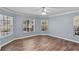 Light-filled bedroom with wood floors and two windows offering natural light and views of the surrounding area at 6731 Northlake Dr, Zephyrhills, FL 33542