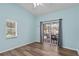 This bedroom has a sliding glass door, hardwood floors and light blue walls at 6731 Northlake Dr, Zephyrhills, FL 33542