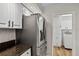 Modern kitchen featuring stainless steel refrigerator and updated cabinets, conveniently located next to the laundry area at 6731 Northlake Dr, Zephyrhills, FL 33542