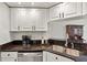 Updated kitchen with stainless steel dishwasher, sink, and white cabinets with dark hardware, creating a sleek design at 6731 Northlake Dr, Zephyrhills, FL 33542