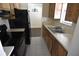 Efficient kitchen with wood cabinets, stainless steel sink, and modern black appliances at 8440 Old Post Rd # 202, Port Richey, FL 34668