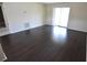 Bright living room with sliding glass door, dark flooring, and neutral paint at 8440 Old Post Rd # 202, Port Richey, FL 34668