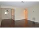 Open living room with dark floors, light beige walls, and connections to the kitchen at 8440 Old Post Rd # 202, Port Richey, FL 34668