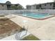 Outdoor community pool surrounded by concrete deck and white fence at 8440 Old Post Rd # 202, Port Richey, FL 34668