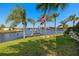 Backyard overlooking the waterfront, including a dock and grass lawn at 9277 St Paul Dr, Port Charlotte, FL 33981