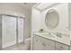 Well-lit bathroom featuring a tiled shower with glass door and a vanity with a sink at 9277 St Paul Dr, Port Charlotte, FL 33981