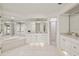 Bright bathroom featuring a soaking tub, glass shower, white cabinets, and tile flooring at 9277 St Paul Dr, Port Charlotte, FL 33981