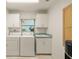 Functional laundry room equipped with a washer, dryer, utility sink, and ample storage space at 9277 St Paul Dr, Port Charlotte, FL 33981