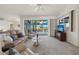 Bright living room with sliding glass doors to pool and a view to the kitchen at 9277 St Paul Dr, Port Charlotte, FL 33981