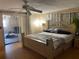Bedroom with light wood floors, fan, large bed, and sliding glass door to back patio at 4800 Fleetwood St, New Port Richey, FL 34653