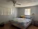 Simple bedroom featuring a bed with blue patterned covers, two windows, and ceiling fan at 4800 Fleetwood St, New Port Richey, FL 34653