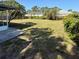 Expansive backyard featuring a covered patio, lush lawn, and mature trees offering ample space and privacy at 5428 Nutmeg Ave, Sarasota, FL 34231