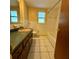 Bathroom featuring a vanity, commode and bathtub with tile surround at 5428 Nutmeg Ave, Sarasota, FL 34231