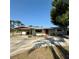 Single-story home featuring a covered carport, red door, and a well-maintained front yard at 5428 Nutmeg Ave, Sarasota, FL 34231