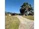 Charming home featuring a curved driveway, mature trees, and a carport, creating a welcoming curb appeal at 5428 Nutmeg Ave, Sarasota, FL 34231